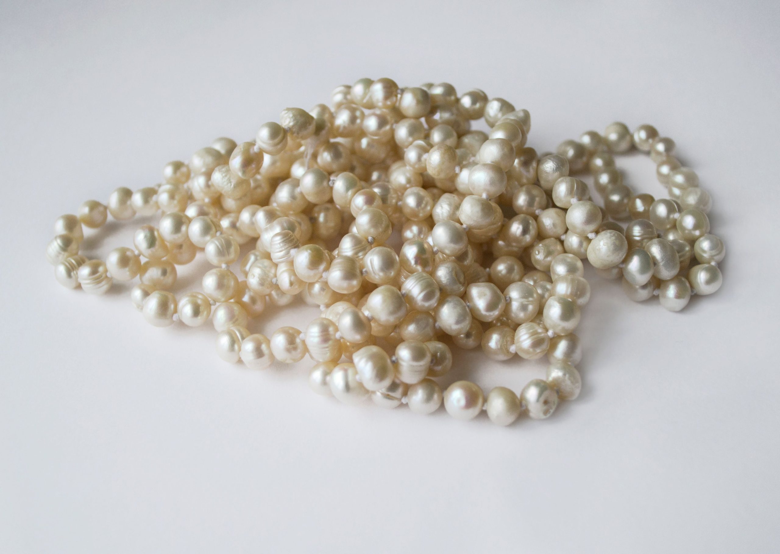 A close-up view of elegant freshwater pearls arranged on a clean white surface, showcasing luxury.